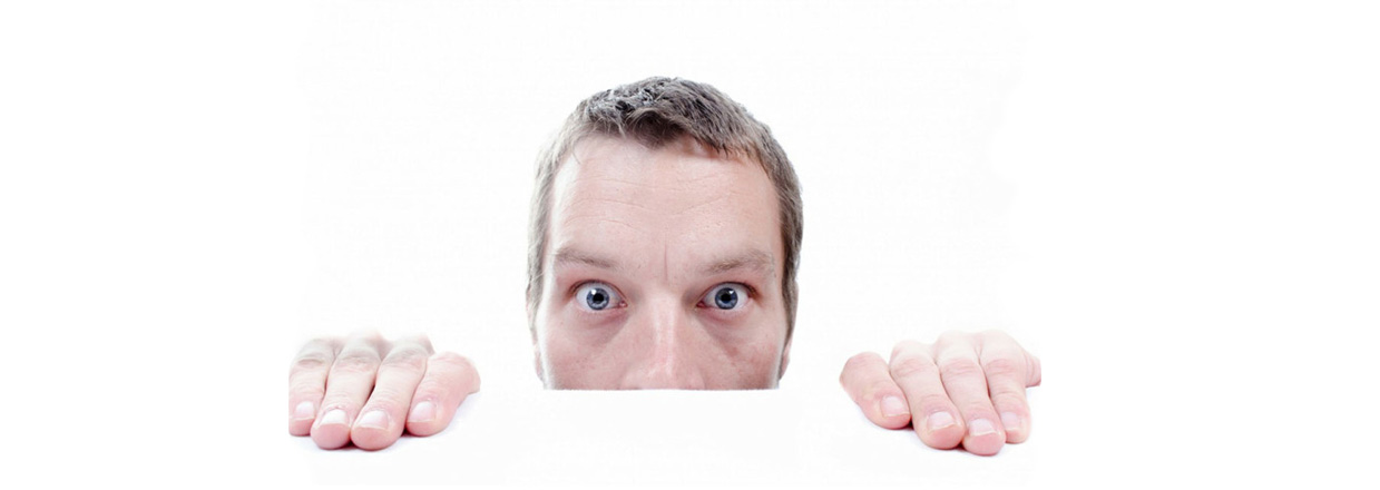 Uomo stupito che sbuca da sotto un tavolo