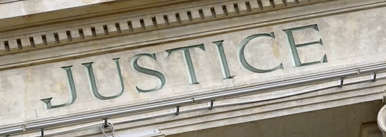 Particolare architettonico di un tribunale con incisa la scritta "Justice"